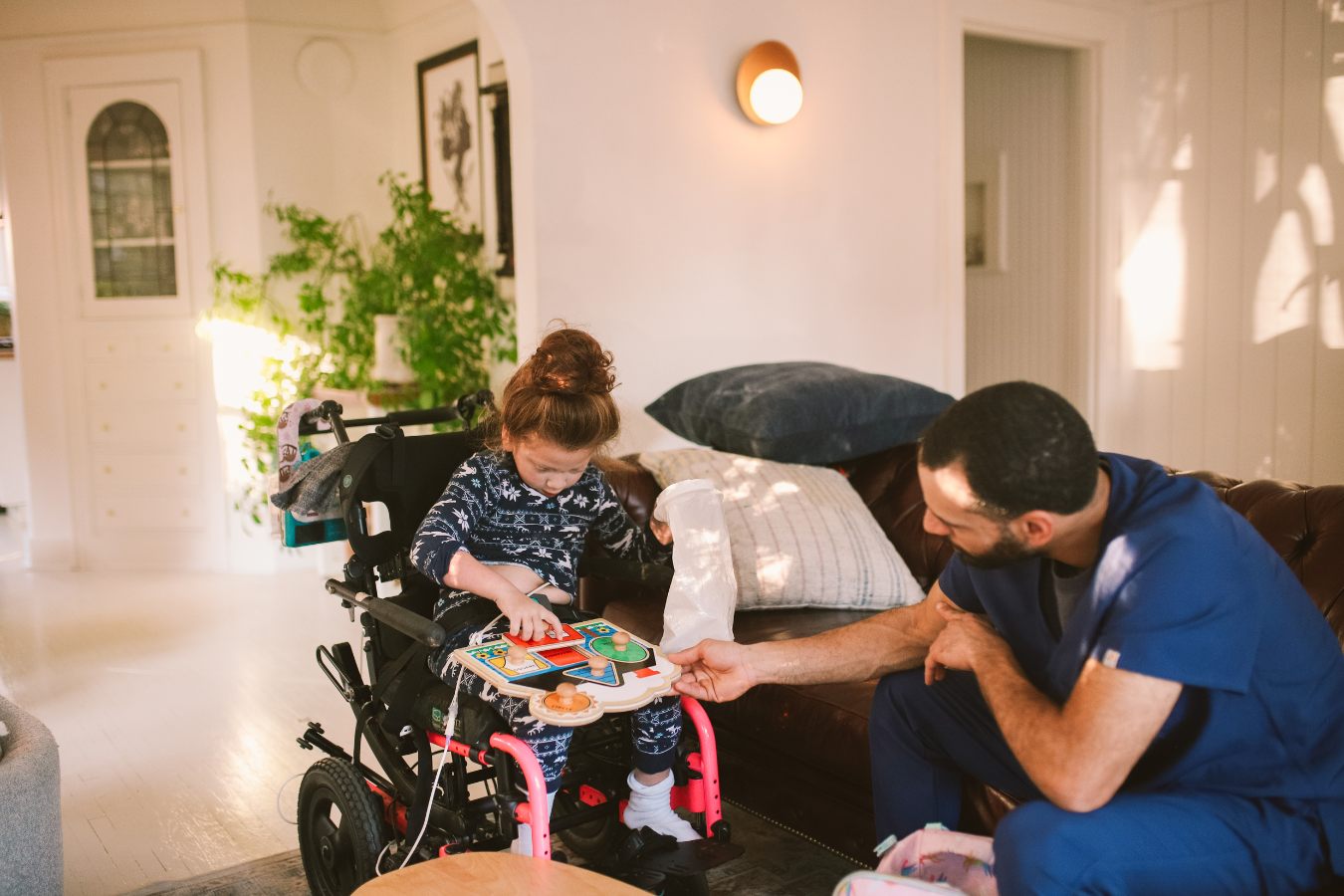 A child and a health care professional play a game within a residential care facility.